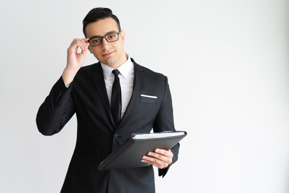 serious-handsome-young-businessman-adjusting-glasses-holding-folder